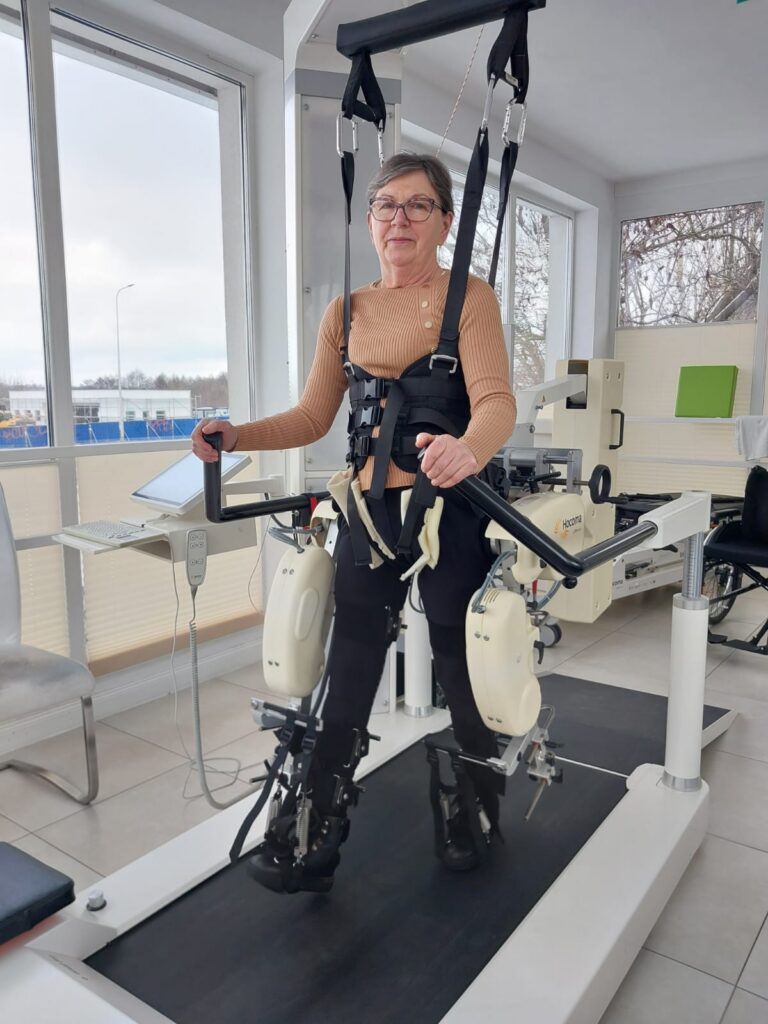 Bronisława Opiela ćwiczy na urządzeniu do reedukacji chodu.