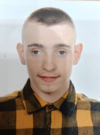 Dawid Puchacz uśmiecha się, ujęty w bliskim kadrze.