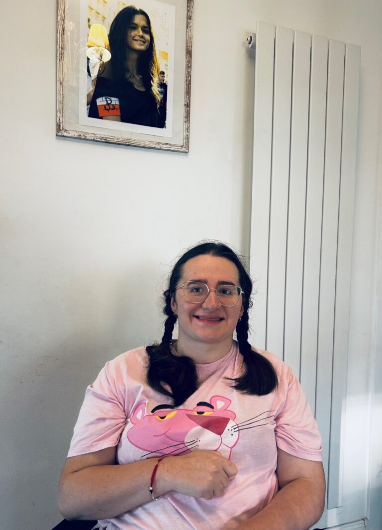 Emilia Skowron siedzi na krzesle i uśmiecha się.