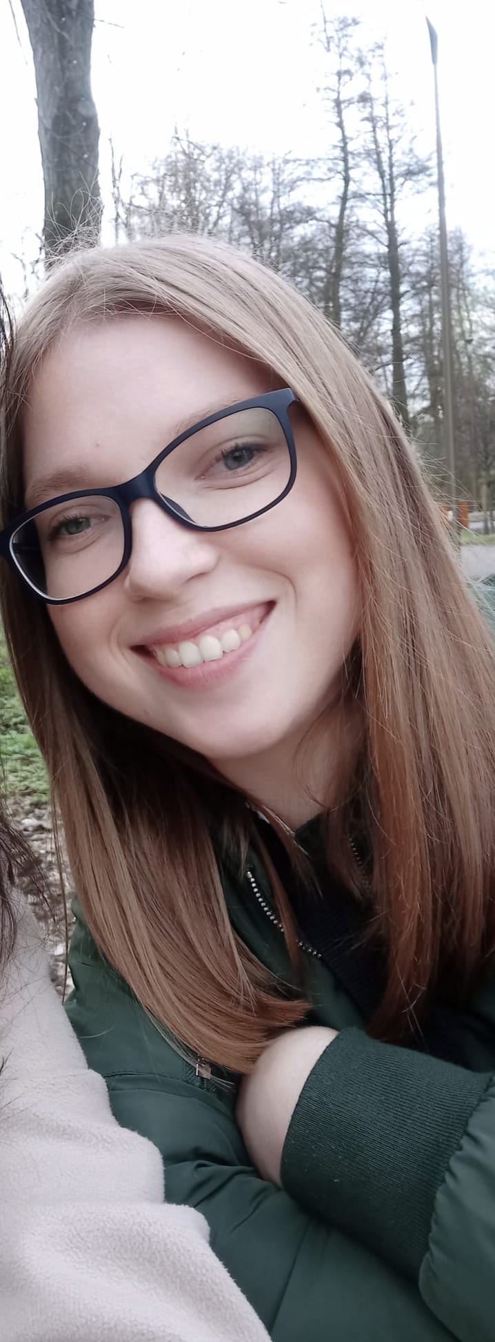 Kinga Rybak uśmiecha się w parku, ujęta w bliskim kadrze.