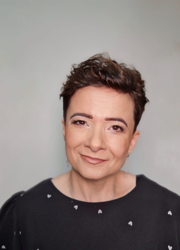 Magdalena Karpiuk uśmiecha się do obiektywu.
