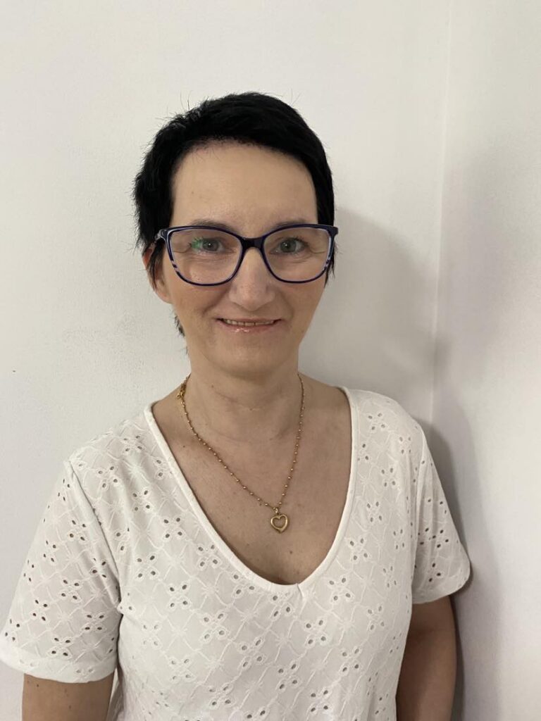 Marta Ciołek lekko się uśmiecha, pozując do portretu.