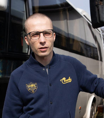 Mateusz Szachtsznajder stoi przy autokarze.