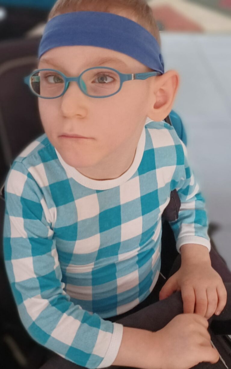 Oskar Kałuża siedzi w foteliku z zapiętym pasem.