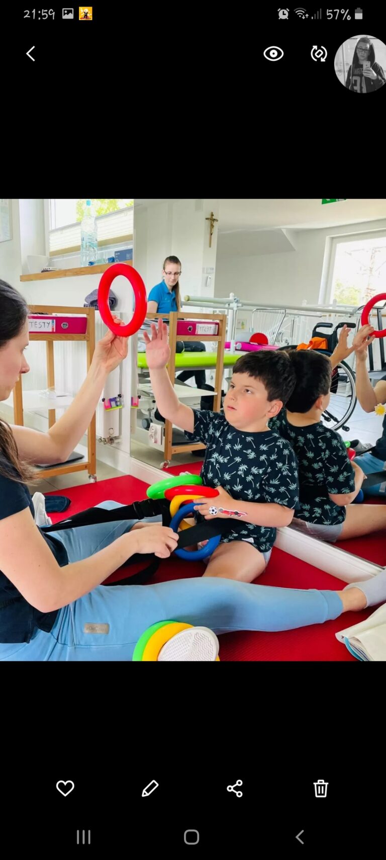 Tymon Surowiec siedzi na macie w sali rehabilitacyjnej i patrzy na kółko do ćwiczeń.
