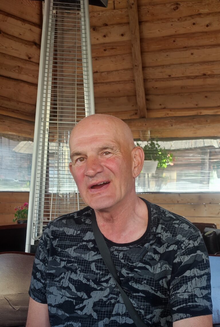 Waldemar Jacyna siedzi w drewnianej altanie.